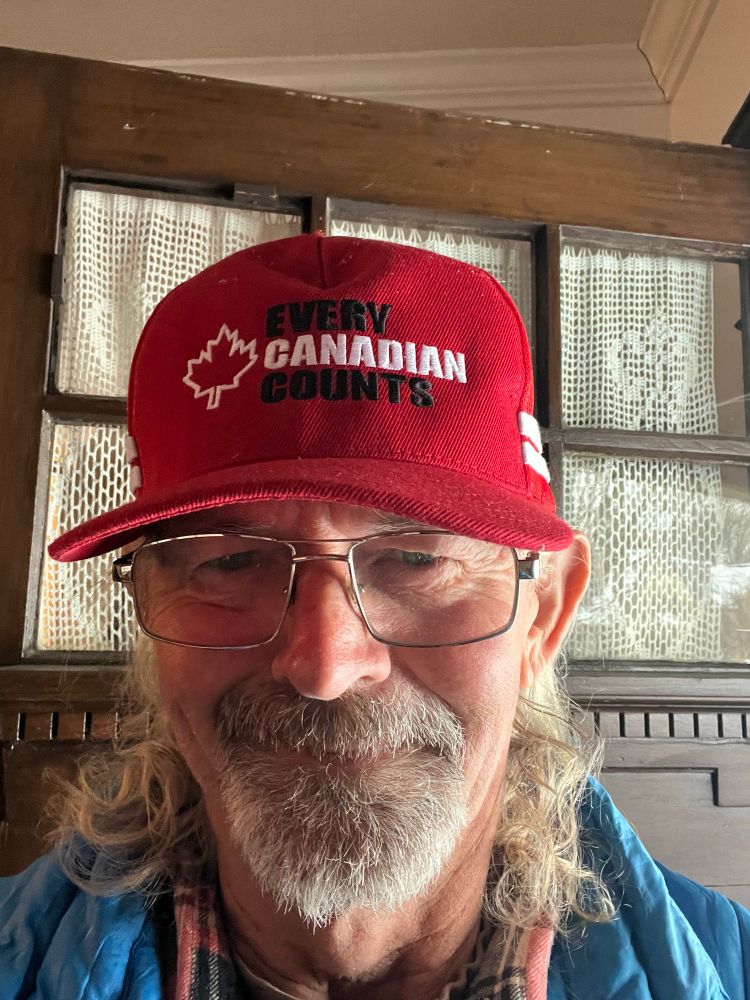 Good looking gentleman with a goatee and wearing glasses. He’s wearing a red hat with black and white lettering that states.
EVERY CANADIAN COUNTS. The logo on the hat belongs to the nonprofit organization, Every Canadian Counts.
