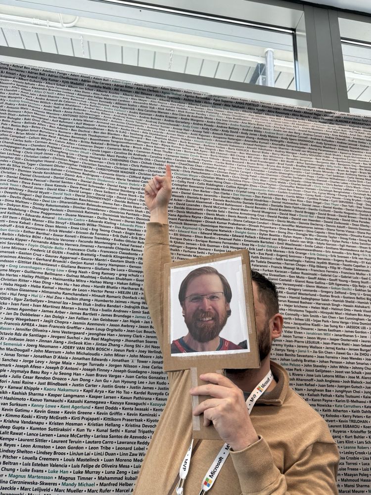 Adam Gross pointing and smiling at his own name at the MVP summit