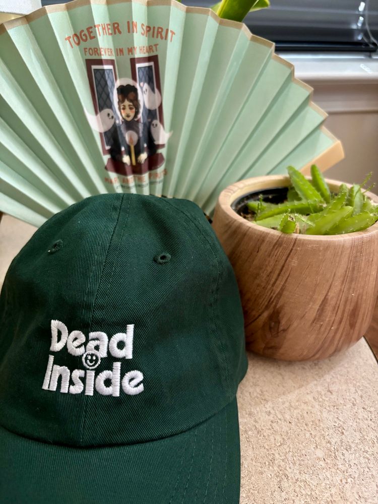 A Mary Todd Lincoln fan that says “together in spirit forever in my heart” and a green baseball cap that says “dead inside” with a smiley face