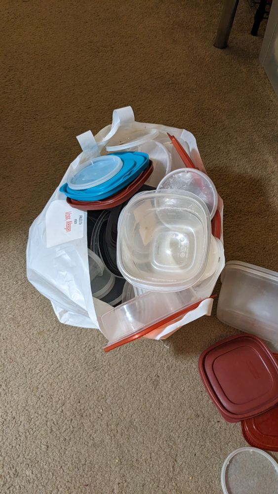 This is a white plastic bag overflowing with tupperware because it seems to me that tupperware spawns spontaneously like alien seed pods.