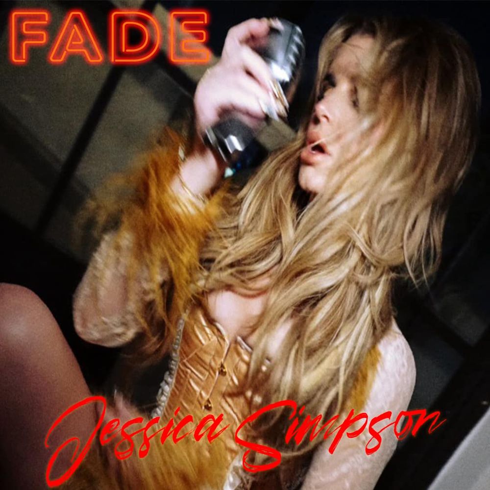 Blurry, emotional close-up of Jessica Simpson with tousled hair, holding a Shure-style microphone near her face, wearing a gold corset with feathered sleeves. The word “FADE” glows in red neon text in the top left, and her name, “Jessica Simpson,” appears in red script at the bottom.