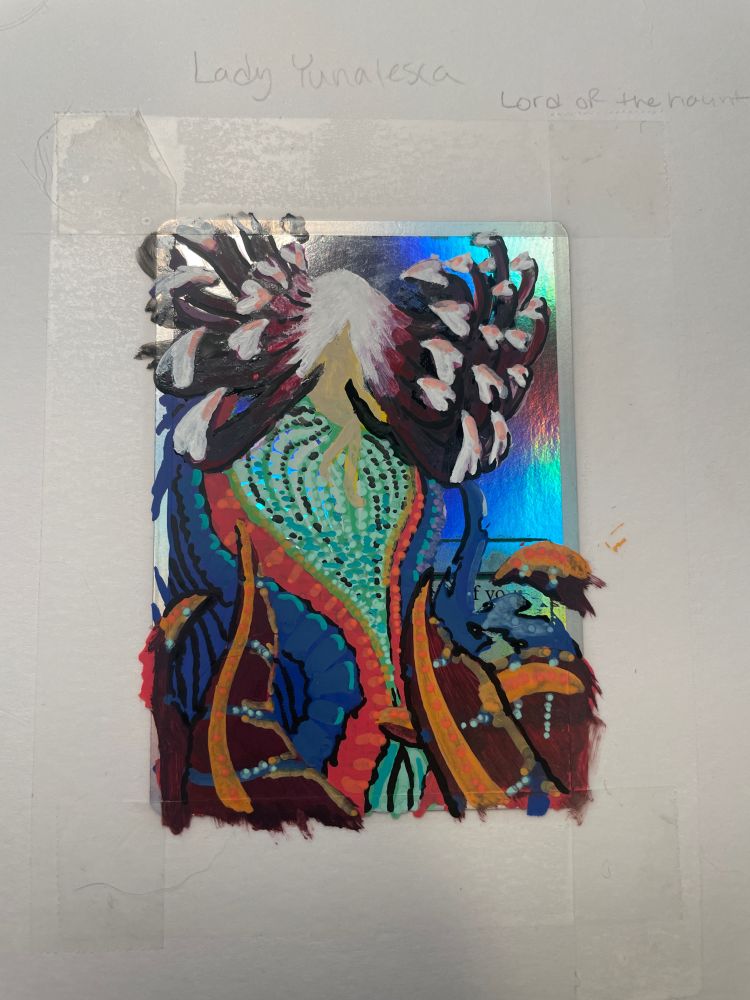 In progress photo of a striped magic the gathering card with a new tentacled monster in a rainbow of colors