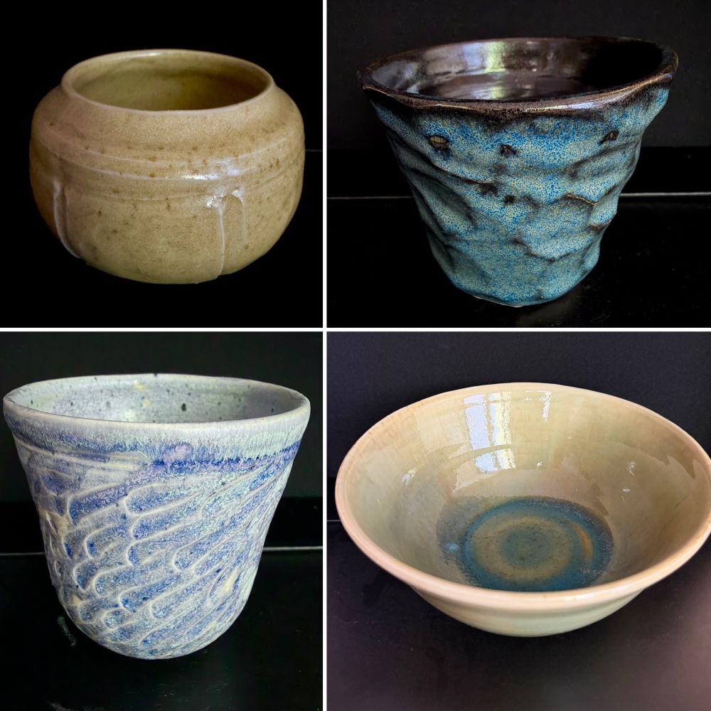 4 handthrown pieces of pottery. A mustard squat rounded form, a faceted mug with blue breaking over black, a light blue carved mug, and a large bowl, with the walls being a light camel but the bottom has pooled to blue