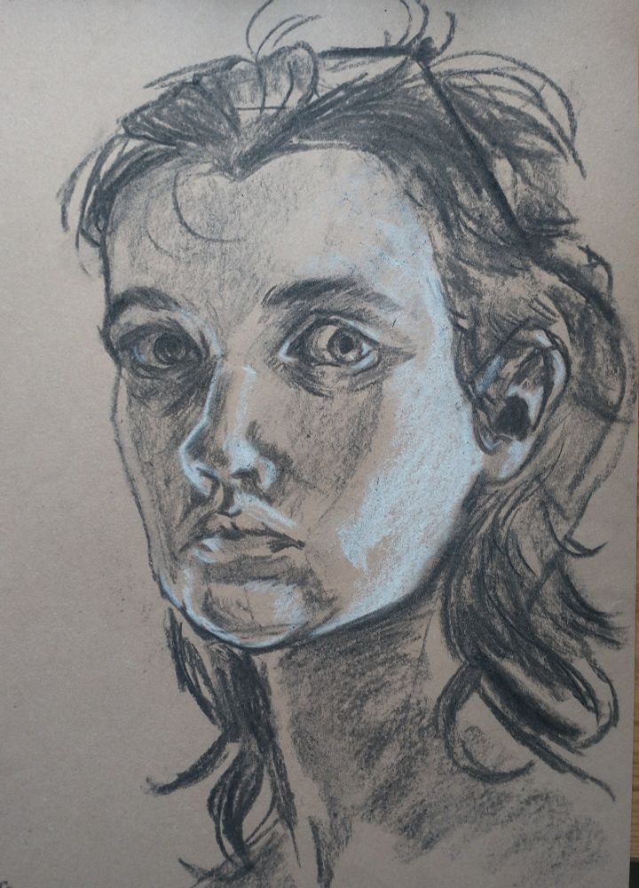 Charcoal and white pastel portrait of a person with long hair and a square face, on buff coloured paper. Their hair is pulled back by a pair of glasses on top of their head, and their eyes are wide. 