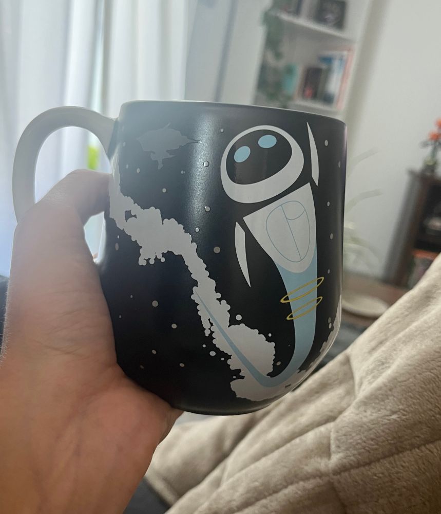 Backside of the same black mug with Eve flying through space