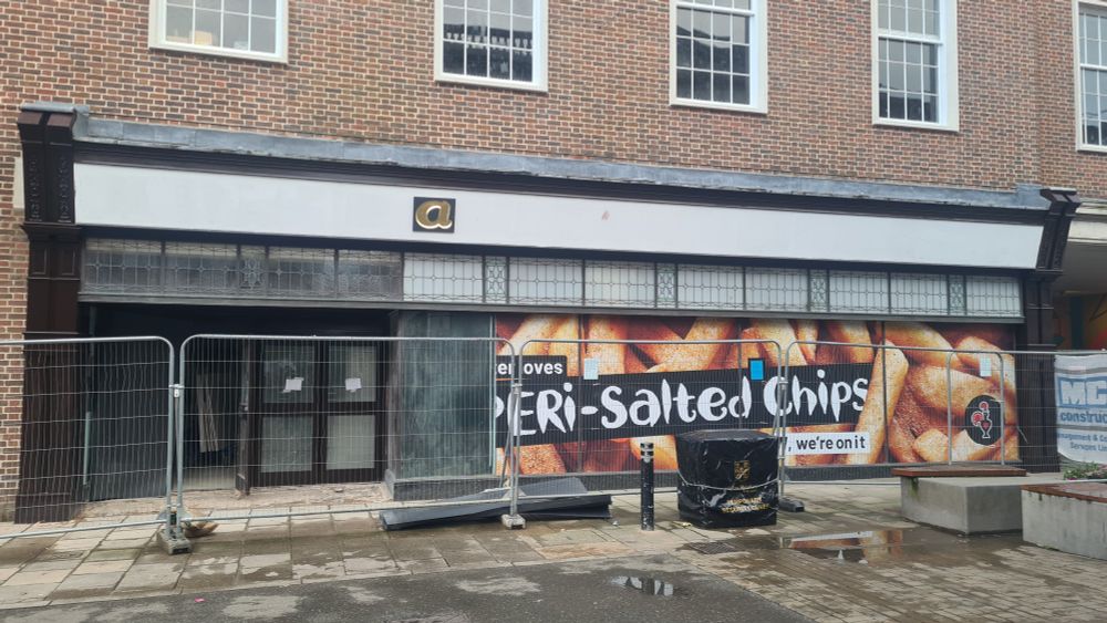 Photograph of a shop front in Winchester High Street with the letter 'a' on the signboard above.