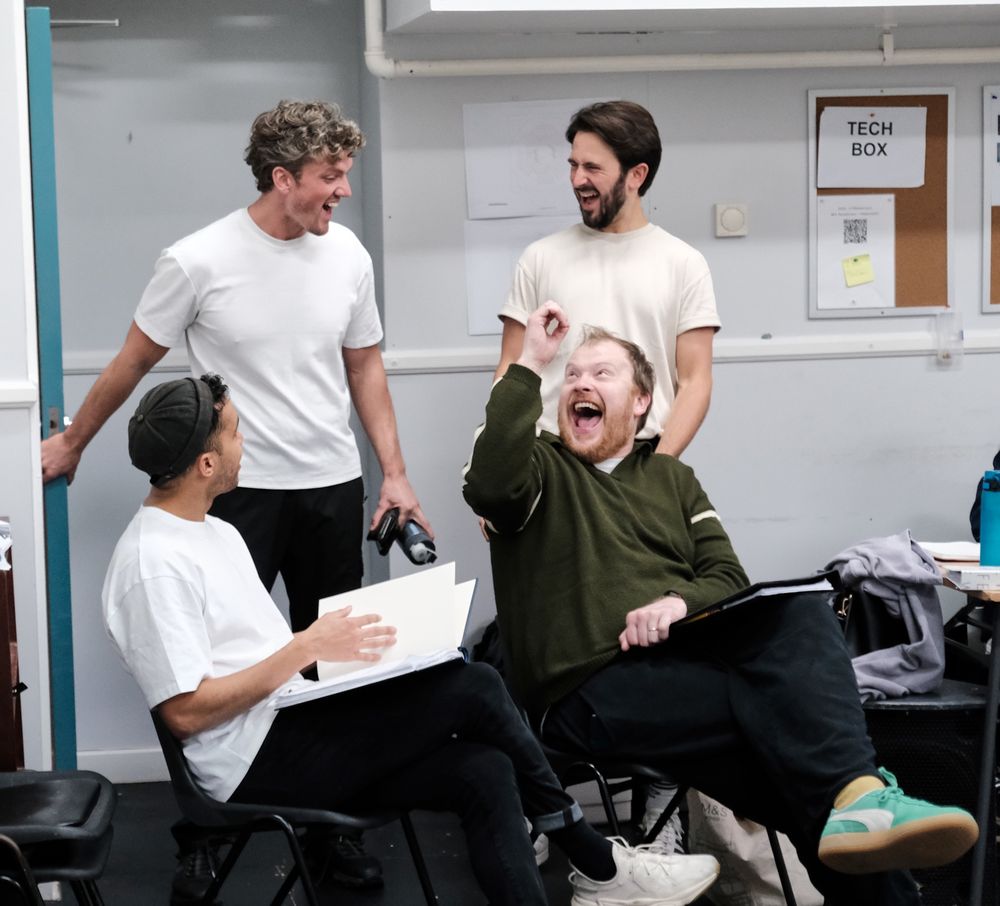 A group of four men laughing. 