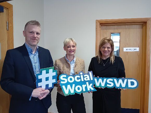 Photo of Chief Executive Amanda Stewart with Directors of Operations Stephen Hamilton and Gillian Montgomery holding signs saying Social Work and World Social Work Day