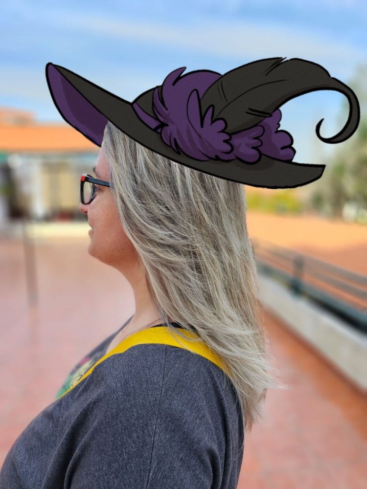 Ale is awesome, in a witch hat. Long silver hair, looking to the left, in profile.