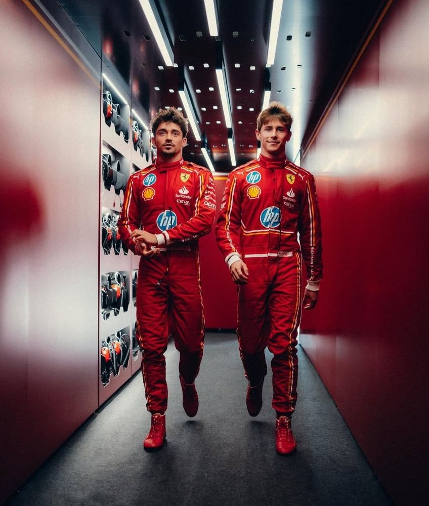 Charles Leclerc and Arthur Leclerc walking together in the Ferrari garage.