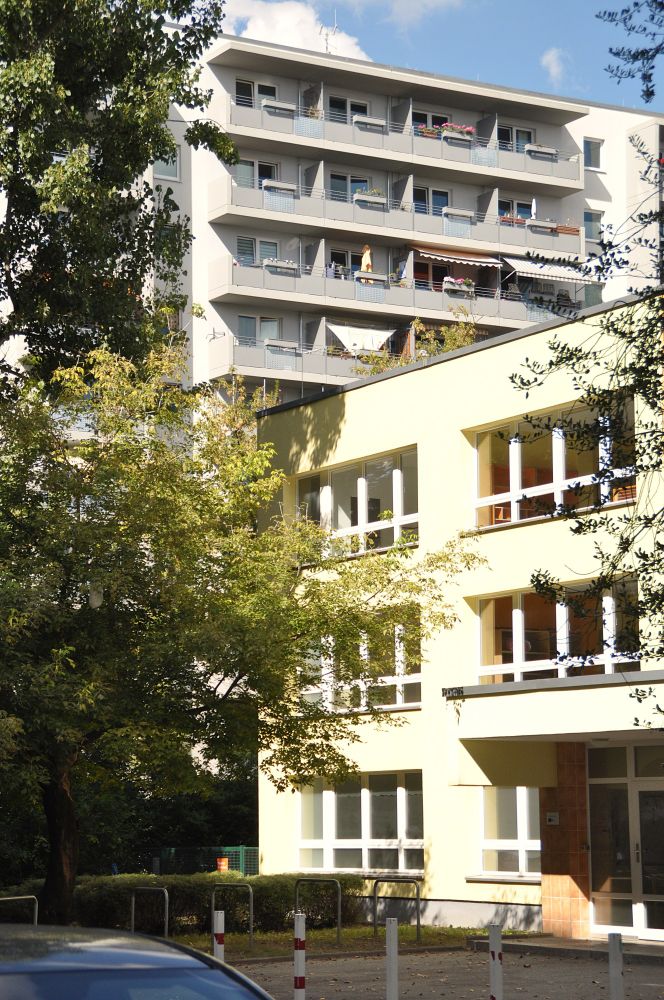 vorne schulflachbau hinten hochhaus.