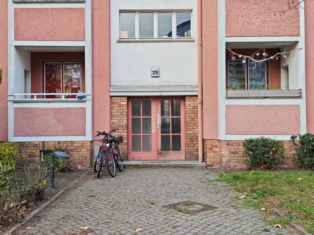 Außen an Sicht eines wohnhauses, das Erdgeschoss der Eingang und rechts und links ein Balkon bzw. Loggia
