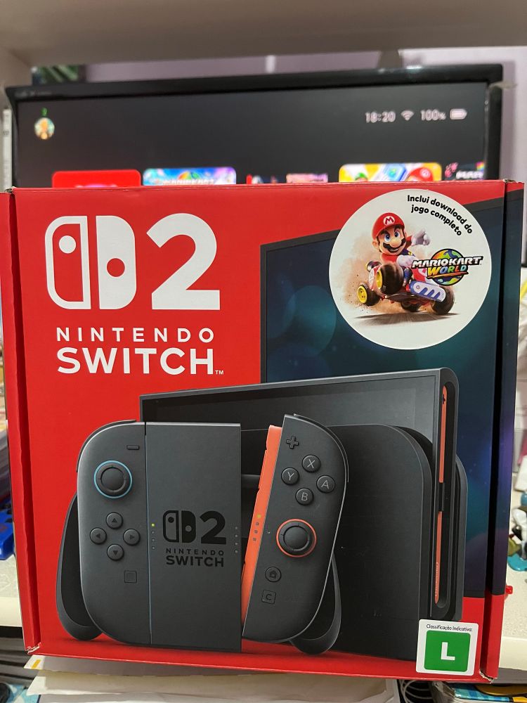 Nintendo Switch 2 com uma TV ligada no plano de fundo.