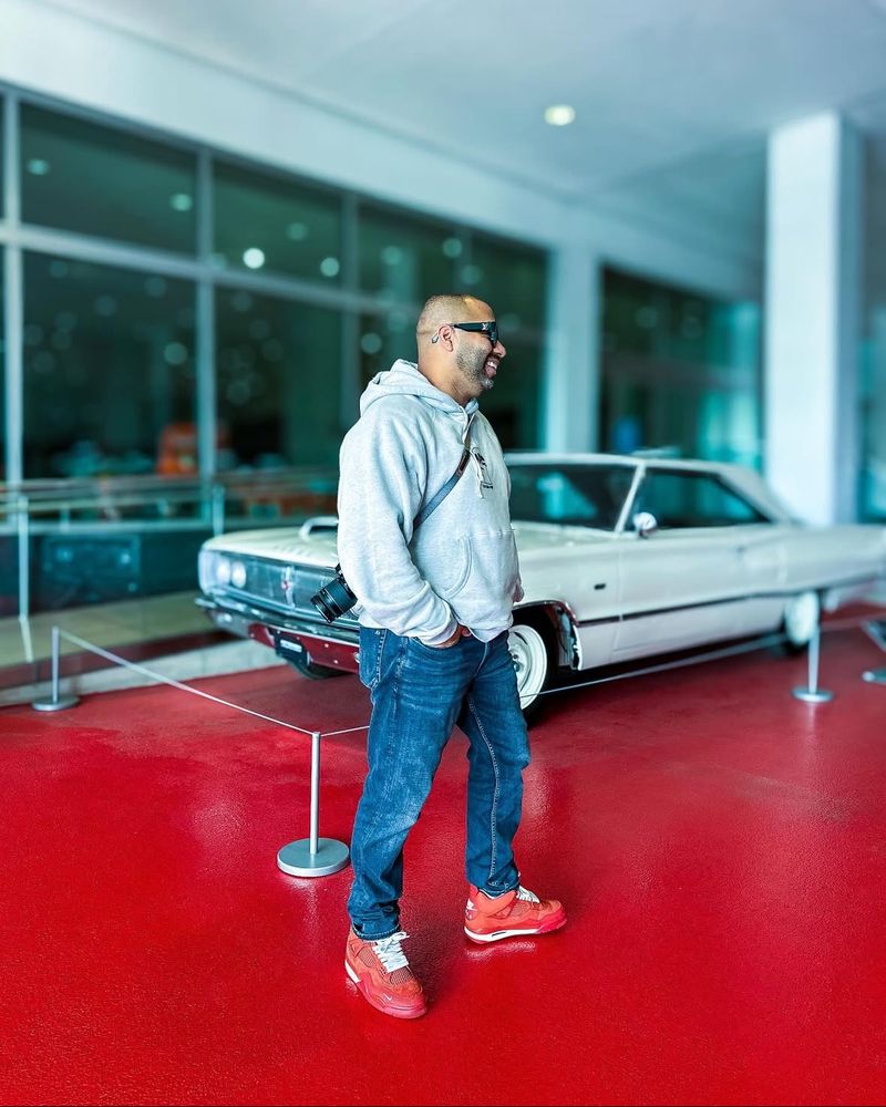 Job standing in front of a car