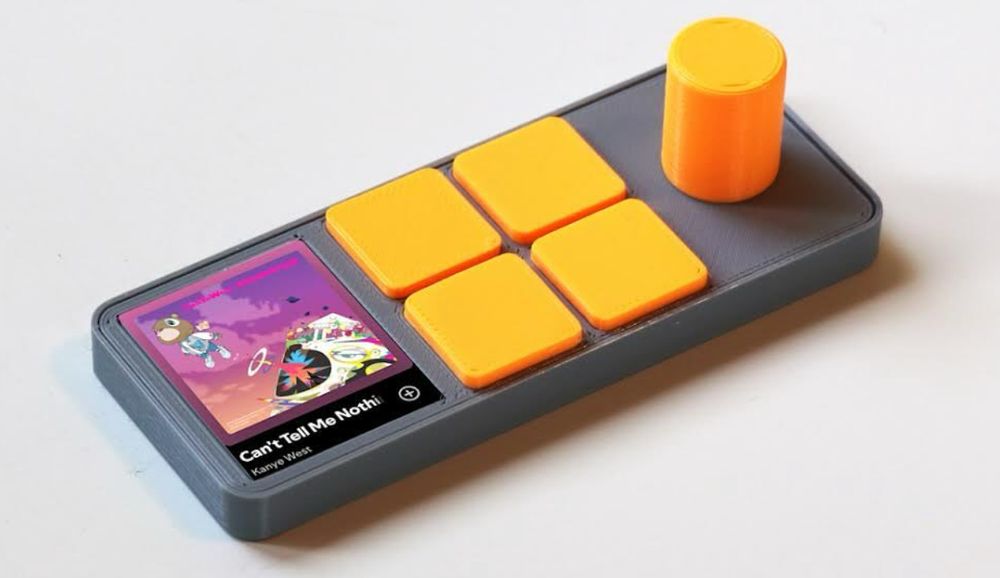 Render of a hardware controller for Spotify, with a small display for album art, four buttons and a big knob.