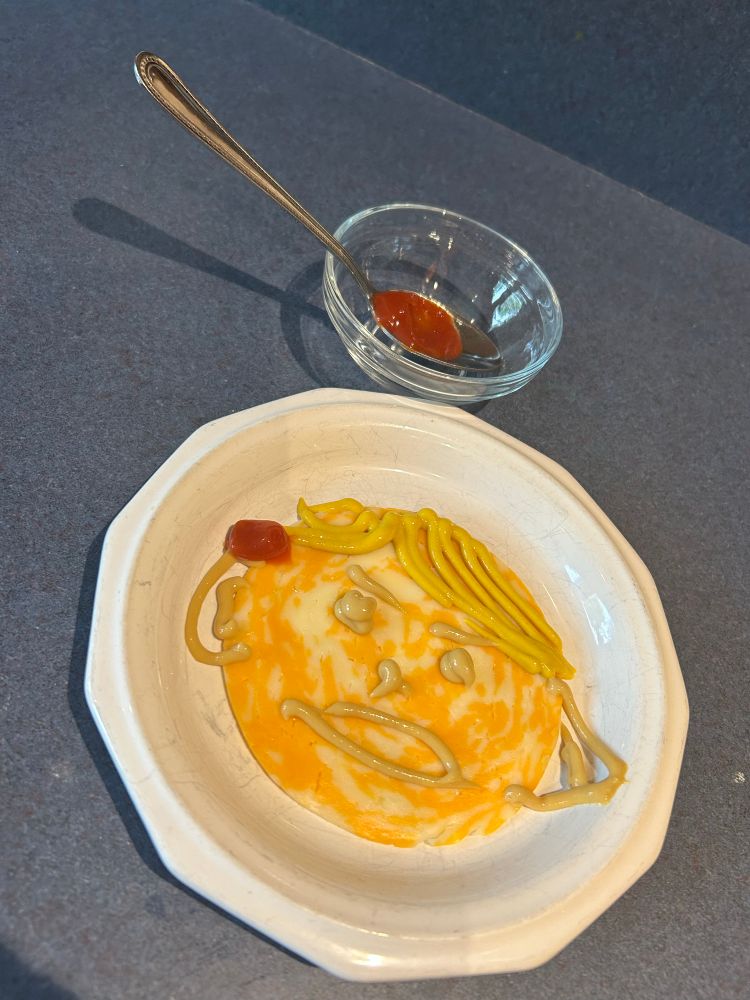 Piece of cheese with mustard that looks line trump with a dab of ketchup on the right ear to show the fake wound!! 