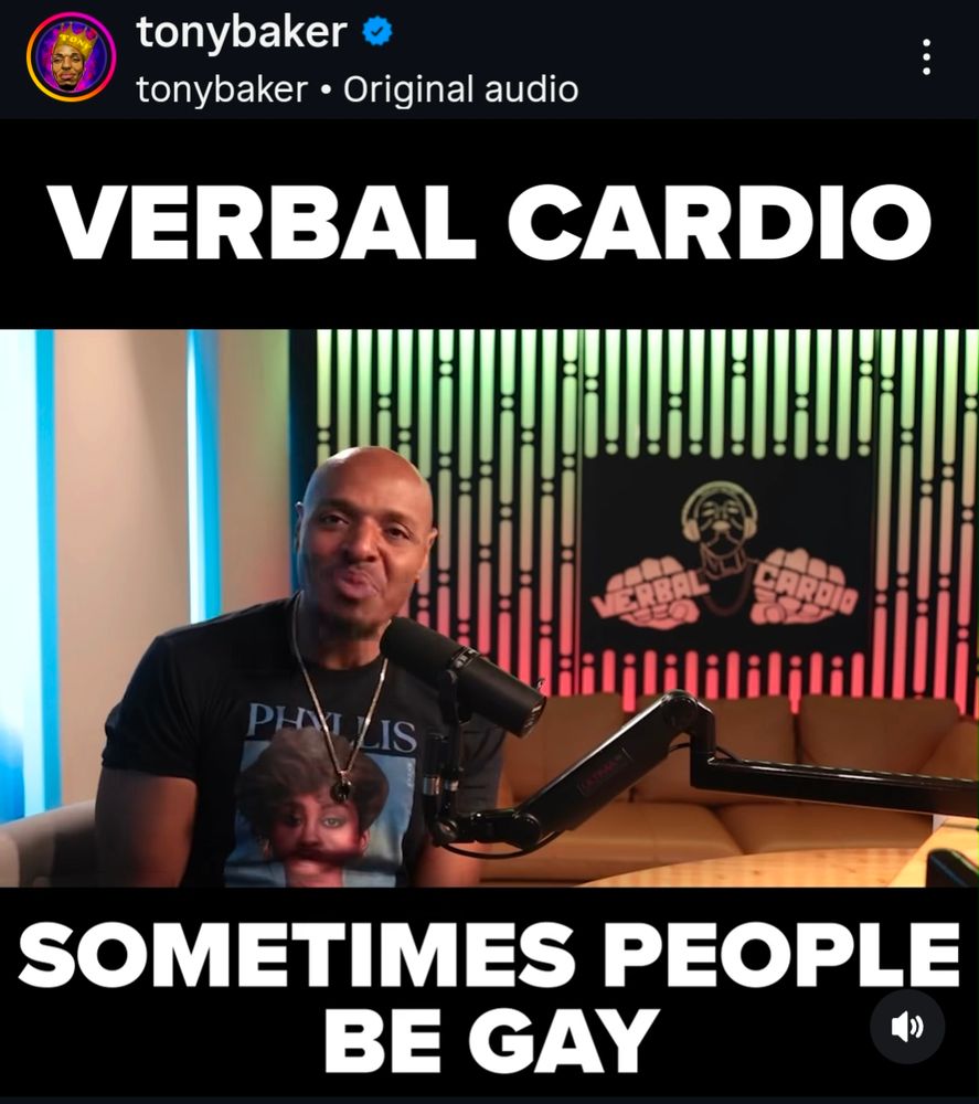 An Instagram post from comedian Tony Baker. Tony Baker sits at a desk with a mic in front of him. 

 text reads: sometimes people be gay.
