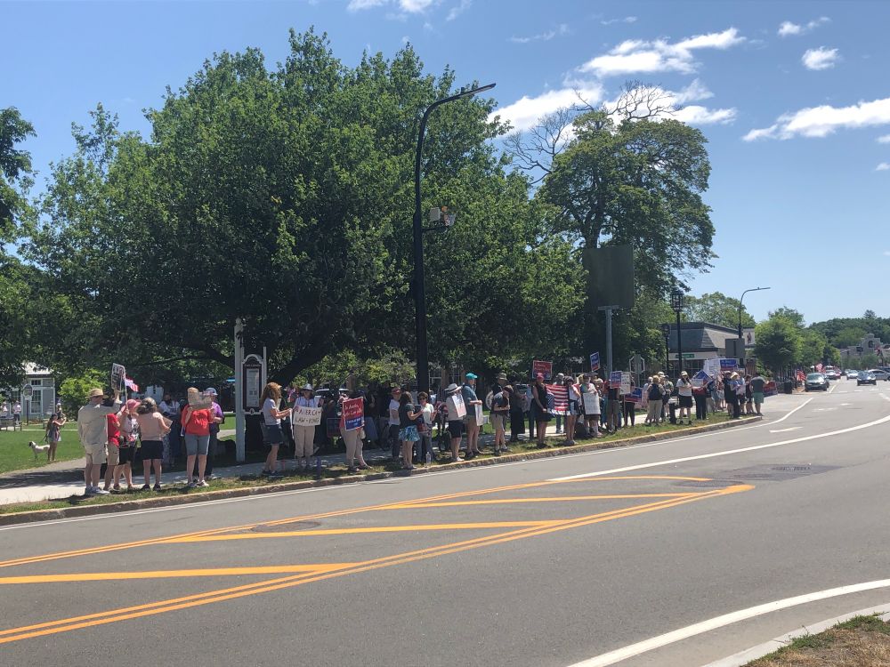People holding signs saying #NoKings #NoTyranny and In America the Law is King in #LexingtonMA on #July4 