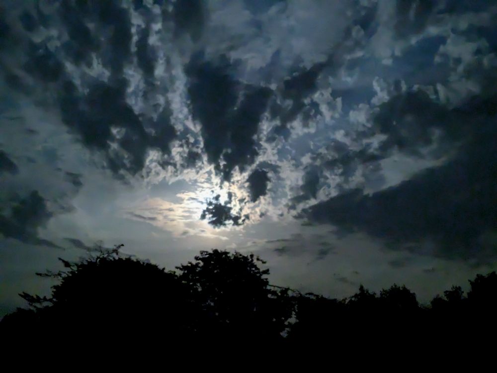 The moon, now hiding behind the dramatic cloud formation 