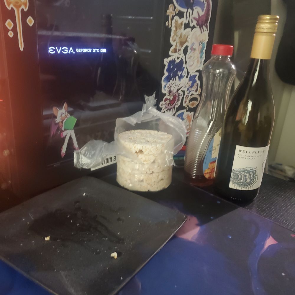 Rice cake, syrup, and wine sitting on a desk next to an empty plate