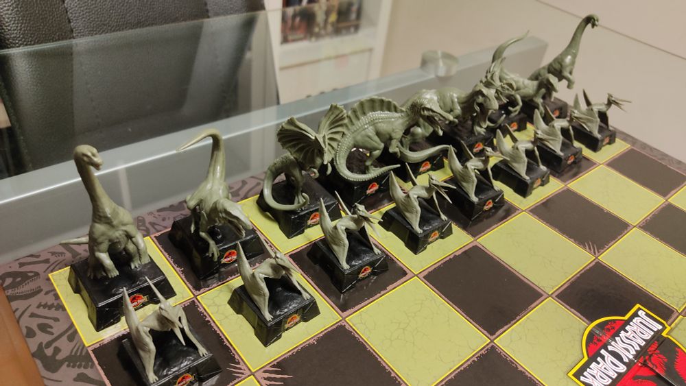 Primer plano de las fichas "blancas", que son más bien verdosas. Los peones son pterodáctilos, las torres son brachiosaurus, los caballos velocirraptor (en realidad son deinonychus, que es lo que son los velocirraptor de Parque Jurásico, pero no estáis preparados para esta conversación), los alfiles dilophosaurus, la dama spinosaurus y el rey el T-Rex.