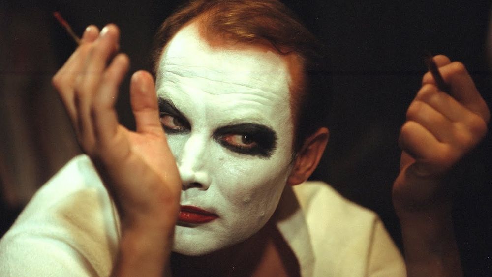 His face made up in white greasepaint, smoky-eyed and red-lipped, a Nazi-era stage actor (played by Klaus Maria Bandauer) examines himself in the mirror in a scene from István Szabó's 1981 film Mephisto.