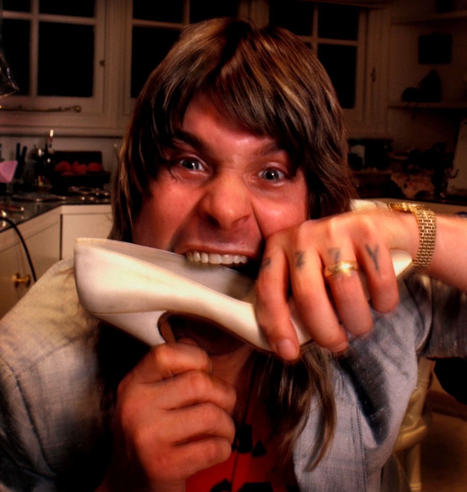 rock star Ozzy Osbourne  eating a shoe of Marilyn Monroe from his personal shoe collection at his home in Hampstead, London, 1985.   