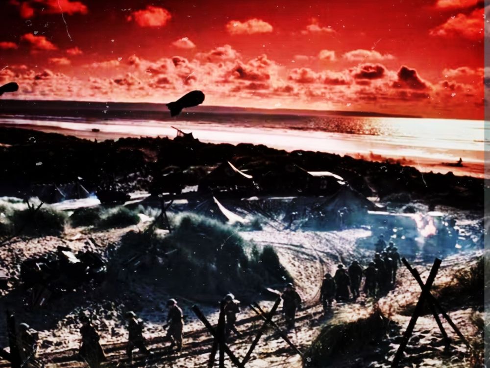 Paysage apocalyptique, ciel rouge et colonne de soldats avançant au premier plan,sur un chemin enneigé bordé de trépieds défensifs entourés de barbelés semble-il.