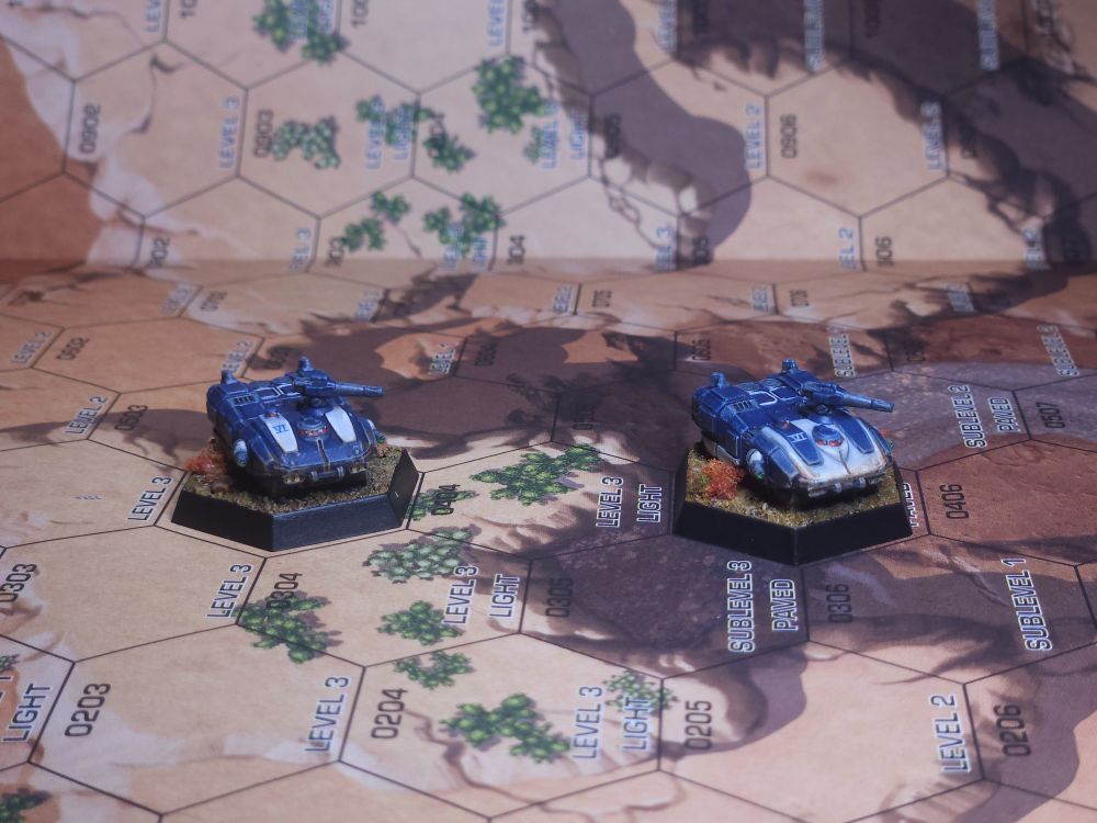 Two Galleon light tanks. The tanks are painted blue with white accents, the same color scheme as the Charger and Whitworth. 