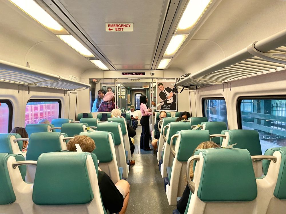 The interior of a Metro-North train, with people seated as well as standing by the doors.