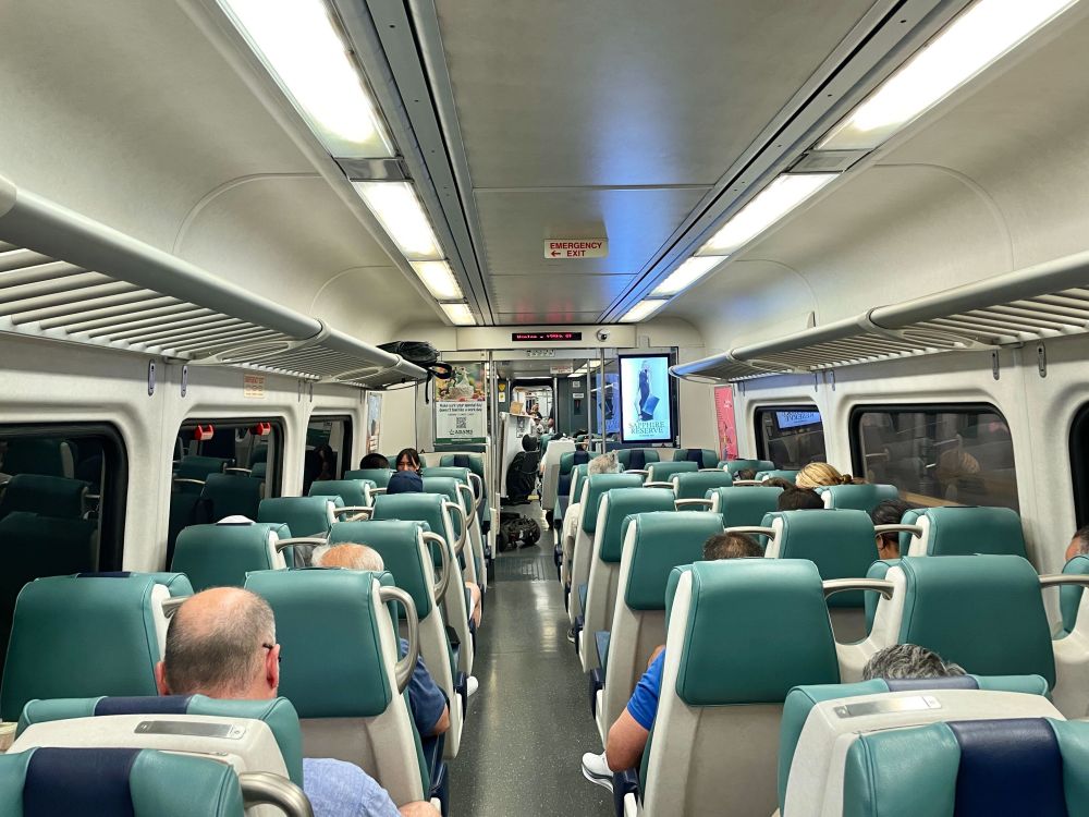 The inside of a Metro-North train, with people seated.