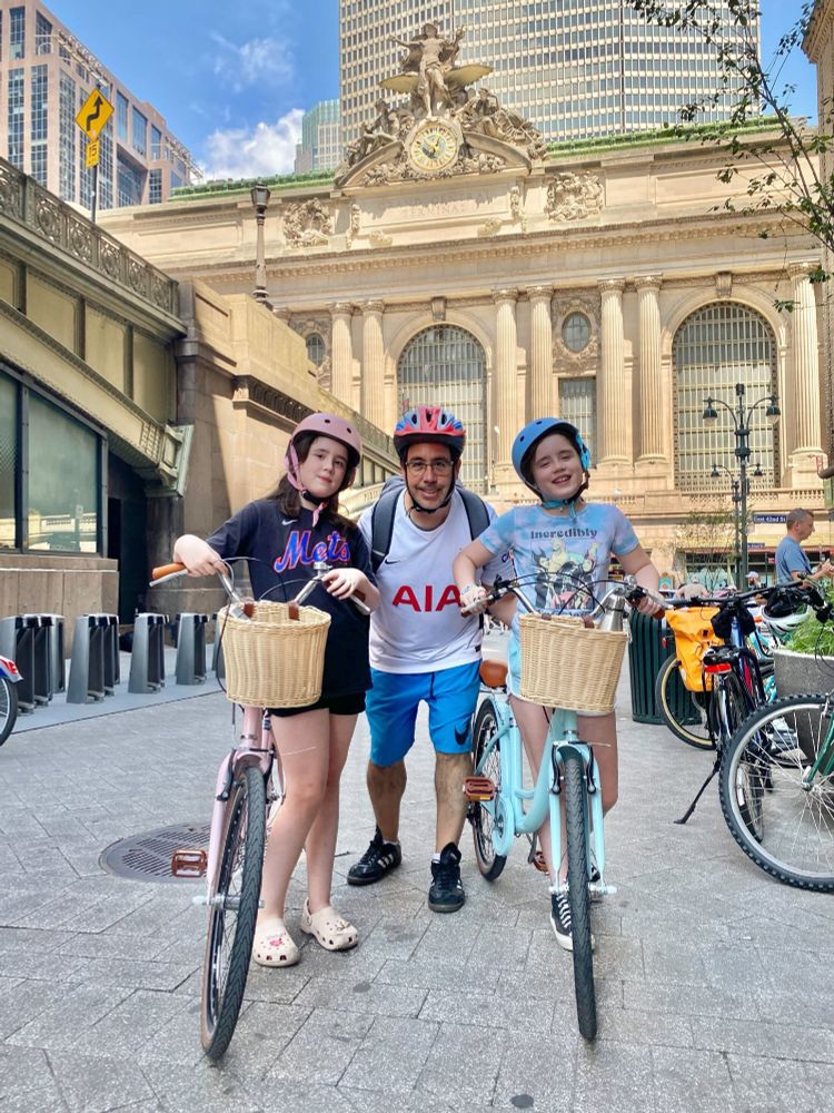 A Metro-North employee posed with his two kids, each wearing a helmet and holding a bicycle.