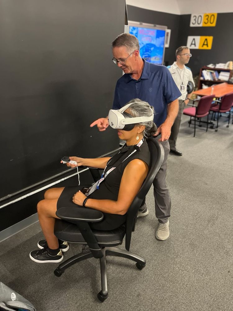 A Metro-North instructor guiding a COMTO attendee wearing virtual reality headgear. 