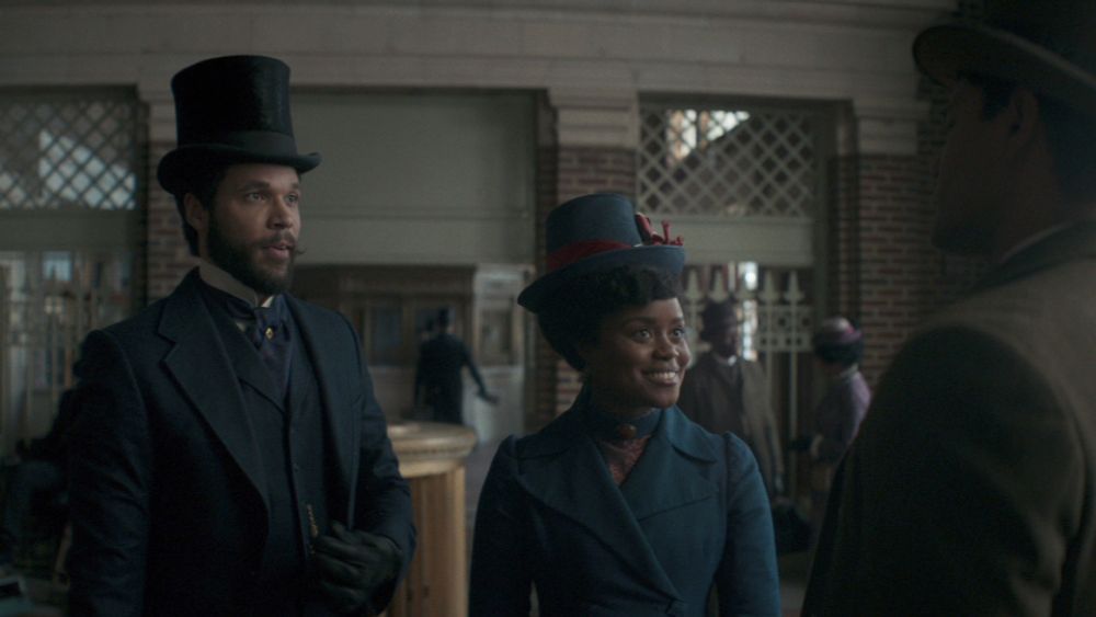 An up-close shot of Denée Benton and Jordan Donica speaking someone in Yonkers Station.