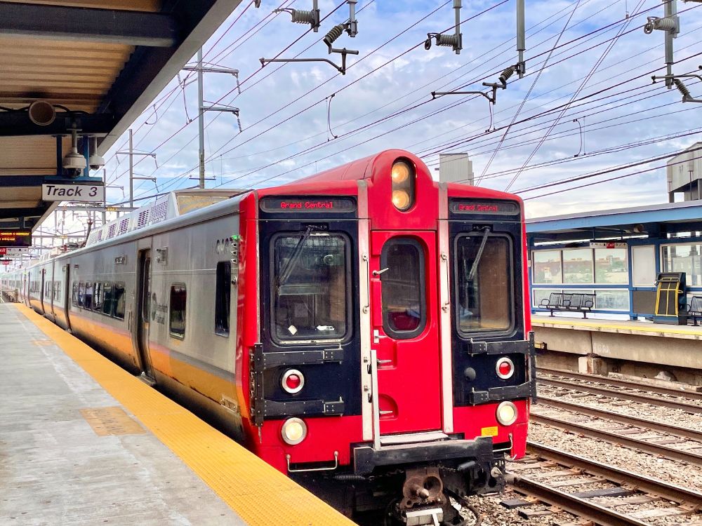 A Metro-North train pulling into a train station on a cloudy day.
