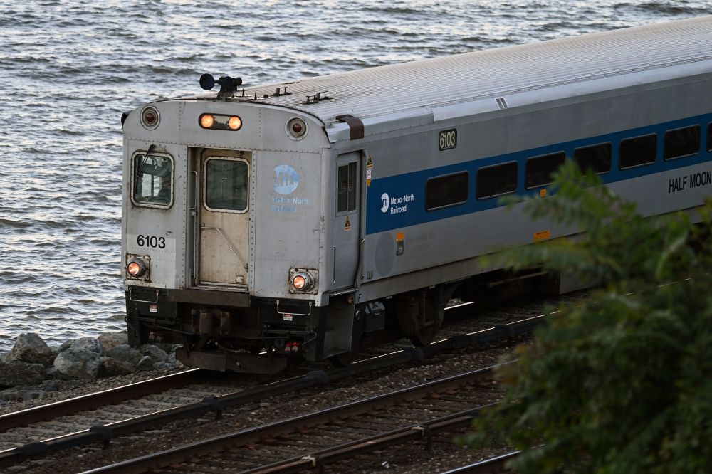 A Metro-North train running along the tracks, along the Hudson River.