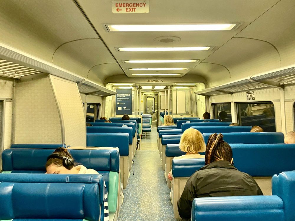 The inside of a Metro-North train, with people seated.