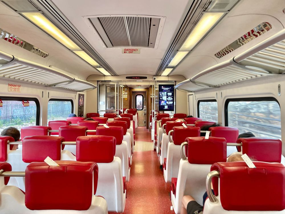 The interior of a Metro-North train with seated passengers. 