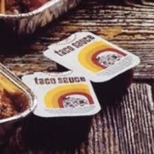 Two Taco Bell taco sauce from the 1970s; they're small plastic cups with peel off lids.