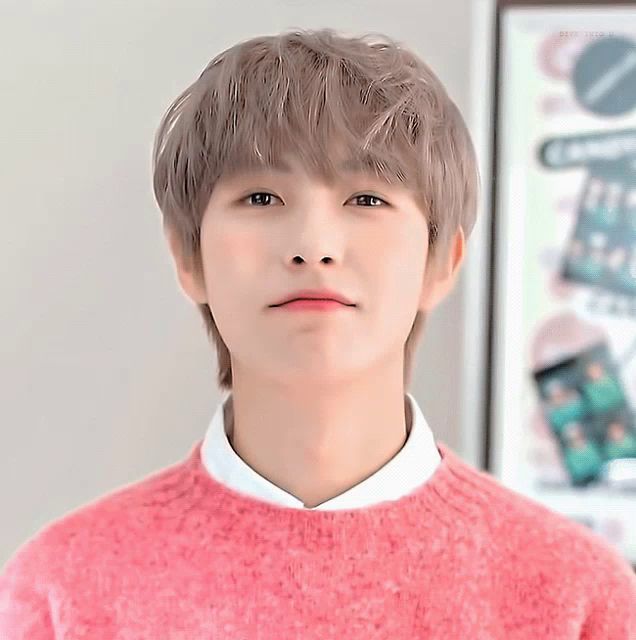 a young man wearing a pink sweater and white shirt