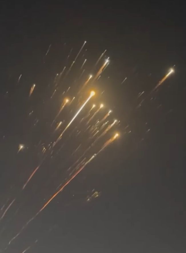 burning debris that looks like a bright meteor shower or fireworks in the dark sky