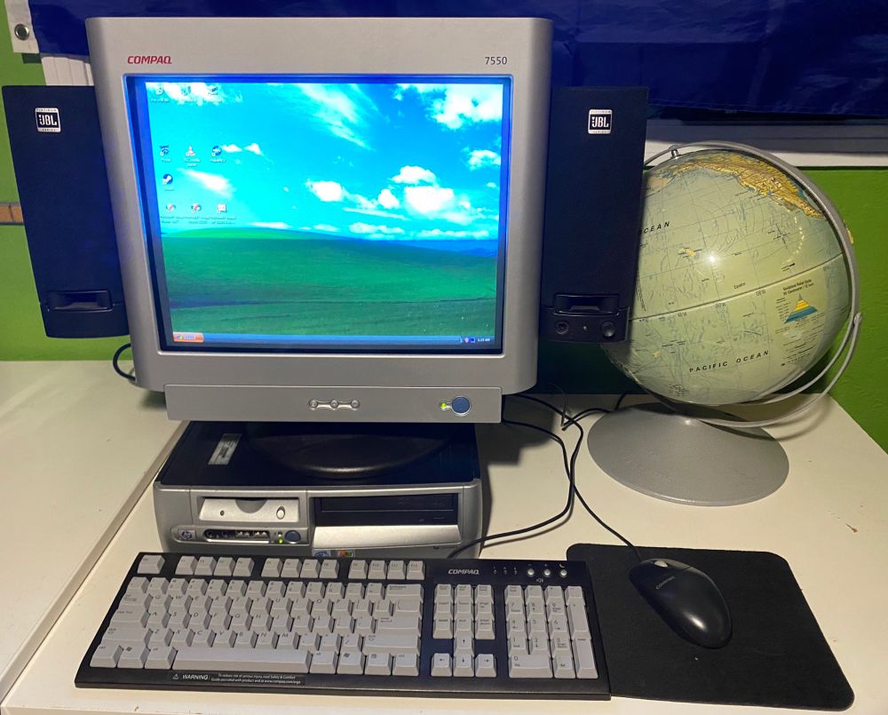 HP Compaq dc5000 Small Form Factor PC with matching CRT monitor and peripherals sitting next to an old globe.