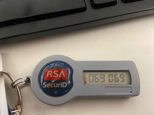 A small, gray RSA SecurID token keychain displays the numbers "069 069" on its digital screen. 