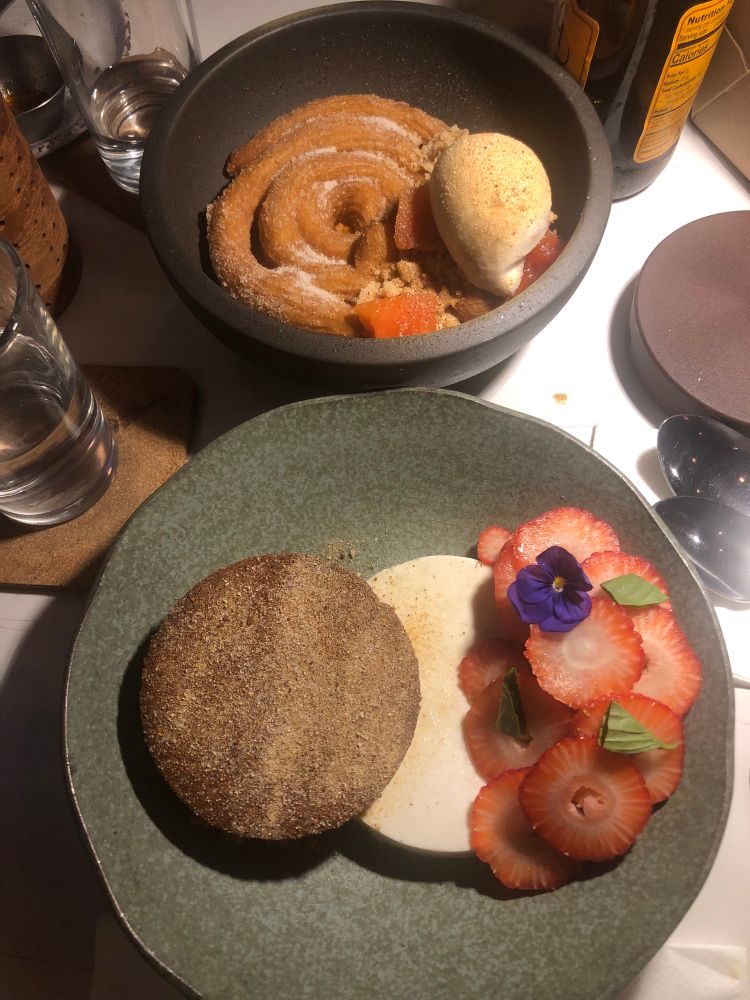 Sweet potato churro with ice cream and a deconstructed cheesecake with fresh strawberries topped with flowers. 