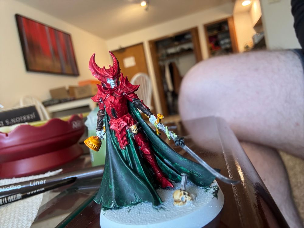 A miniature of a vampire lady. Her Armor is painted red with green cloth and holding a golden chalice.