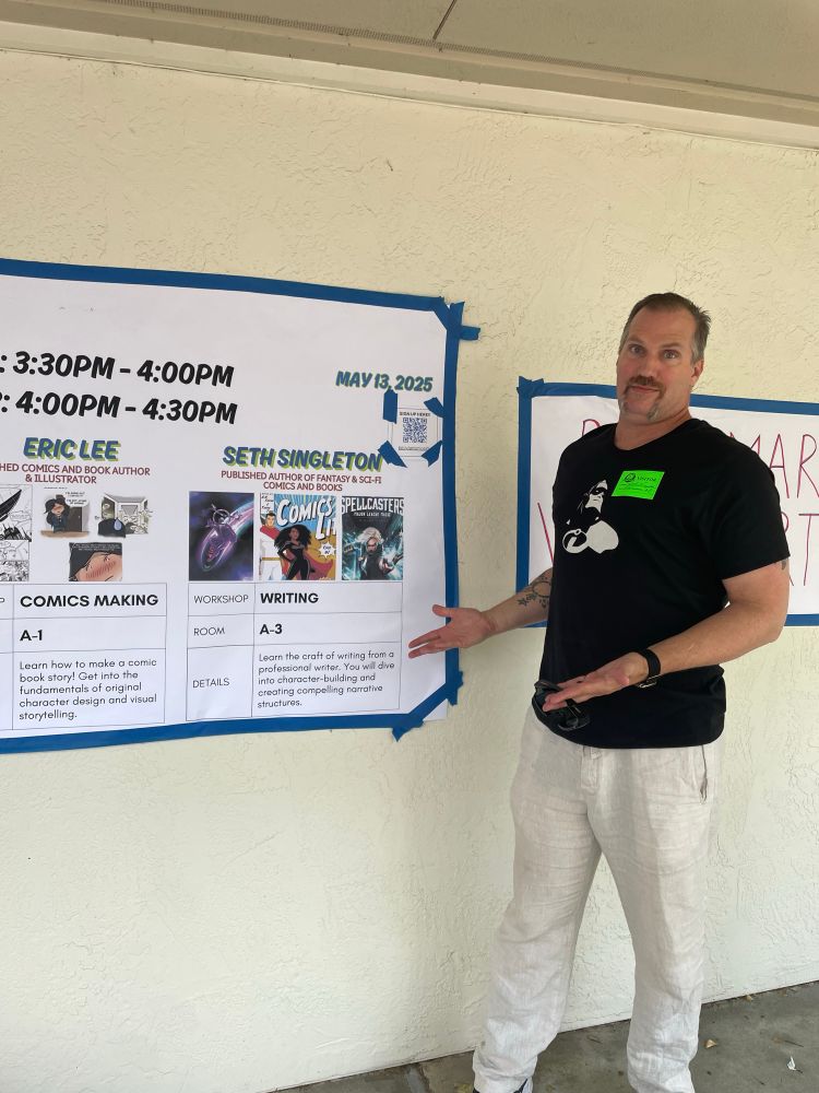 Seth Singleton pointing to the sign for  Art On Ice at Harvest Park School