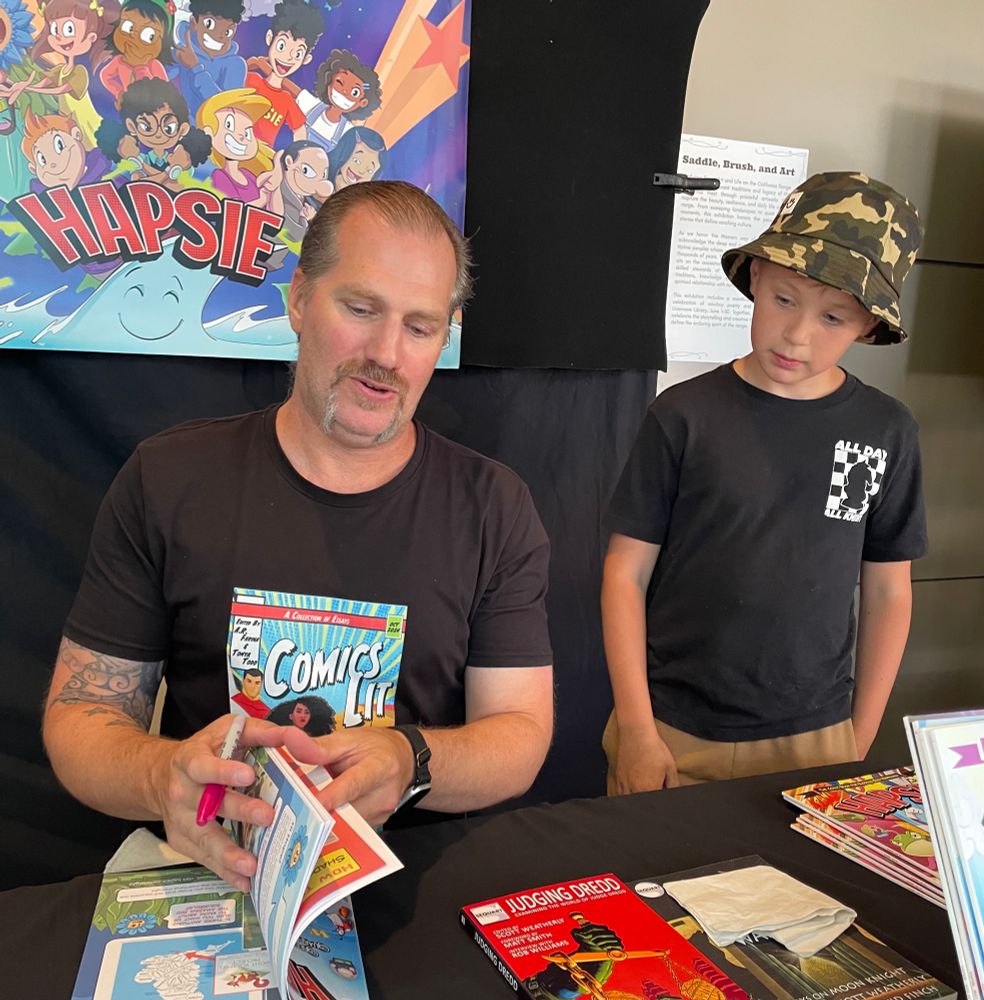 Writer Seth Singleton signing a copy of HAPSIE for a future comic book writer. 