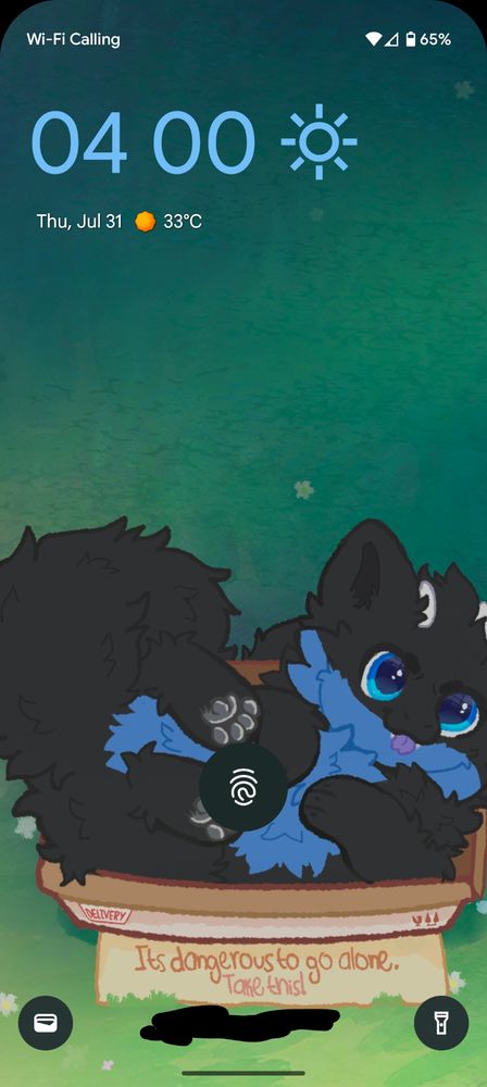 A black fluffy dragon with a blue underbelly lying like a cat on their back in a cardboard box that says "It's dangerous to go alone. Take this!"
