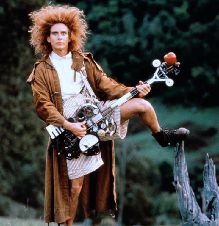 Yahoo serious in shorts and a trench coat playing a crazy guitar. 