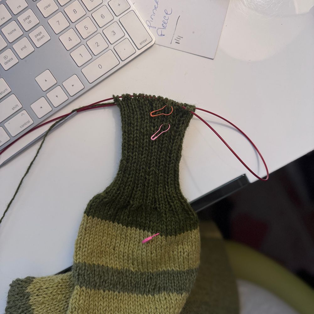 A dark green cuff rests on a bright white desk. 